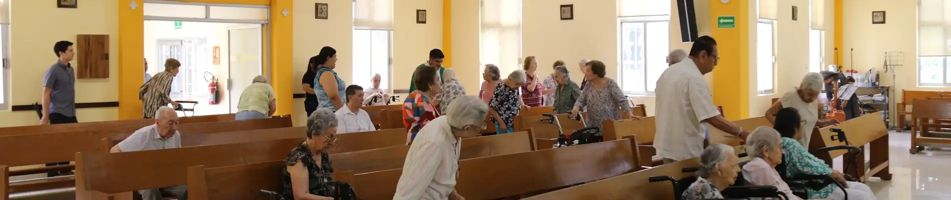 Residentes del asilo levantandose después de concluir la misa