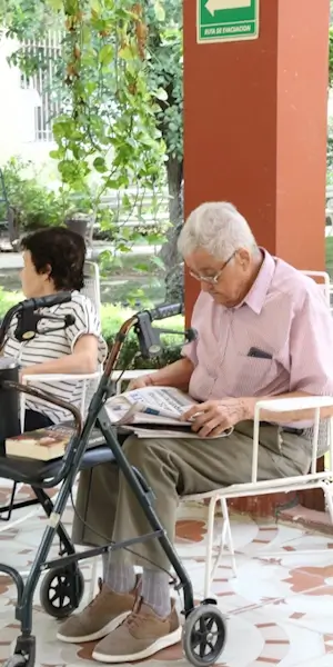 Anciano sentado en el patio leyendo el periódico